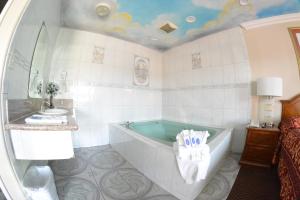 a bathroom with a bath tub and a sink at The Palace Inn in Oxnard +37 photos