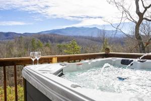 a hot tub on a deck with a glass of wine at Great View Location Studio Log Cabin Hot Tub in Gatlinburg +53 photos
