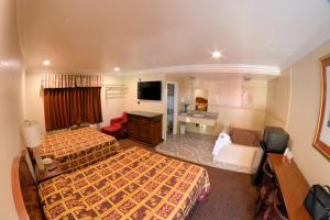 a hotel room with two beds and a television at The Palace Inn in Oxnard