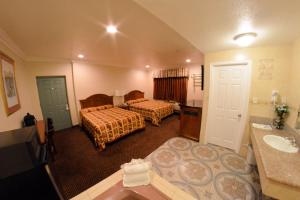 a hotel room with two beds and a sink at The Palace Inn in Oxnard