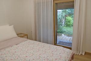 a bedroom with a bed and a large window at Tasha's Garden Private Pension Jeonju Hanok Village in Jeonju