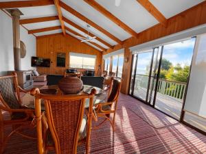 a dining room with a table and chairs and a living room at High On Coffey - Binalong Bay - Pet Friendly in Binalong Bay