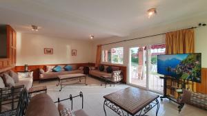 a living room with a couch and a tv at L'oasis d'Agadir - Agadir's hidden Oasis in Agadir