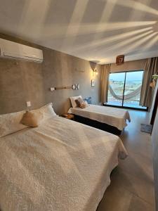ein Hotelzimmer mit zwei Betten und einem Fenster in der Unterkunft Chalé Duplex Beira Mar Macapá in Luis Correia + 14 Fotos