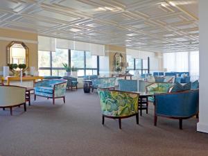 a waiting room with chairs and tables and windows at Pestana Bahia Praia Nature & Beach Resort in Vila Franca do Campo
