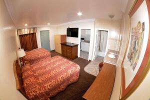a hotel room with a bed and a desk at The Palace Inn in Oxnard