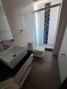 a white bathroom with a sink and a toilet at Beautiful house downtown in Tarija +7 photos