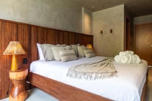 a bedroom with a large bed with a wooden headboard at Casa Bangalô dos Milagres in Passo de Camarajibe +45 photos