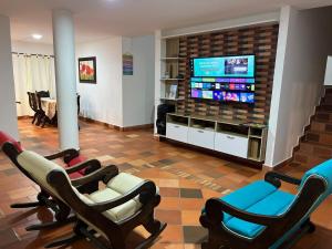 a living room with chairs and a flat screen tv at Parcela villa David mesa de los santos in Piedecuesta