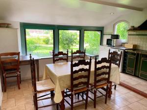 a kitchen with a table and chairs and a kitchen with windows at Maison 8 min du Zoo de Beauval, jardin, cheminée, tout inclus, proche Châteaux de la Loire - FR-1-491-429 in Châteauvieux