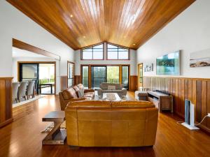 a living room with a leather couch and a tv at Pipe Dreams in Arrawarra