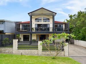 a house with a fence in front of it at Pipe Dreams in Arrawarra