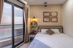ein Schlafzimmer mit einem Bett und einem großen Fenster in der Unterkunft Boutique Home Van Mieu Ha Noi in Hanoi