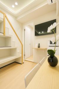 Una sala de estar con una mesa y un televisor. en 誠家 Makoto Hotel, en Tokio