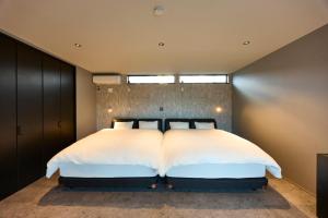 a bedroom with a large bed with white pillows at Ocean Bridge Awaji in Awaji