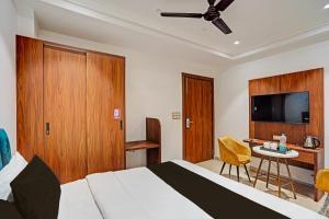 Un dormitorio con una cama, un escritorio y un televisor. en OYO Hotel Signature BNB, en Nueva Delhi 31 fotos más