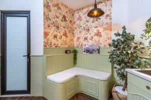 ein Zimmer mit einer Bank mit Blumen an der Wand in der Unterkunft Boutique Home Van Mieu Ha Noi in Hanoi