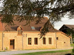 un grande edificio in mattoni con tetto marrone di Maison typique en Berry avec fibre et cour privée - FR-1-591-746 a Étrechet