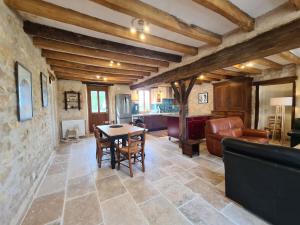 una cucina e un soggiorno con tavolo e sedie di Maison typique en Berry avec fibre et cour privée - FR-1-591-746 a Étrechet