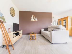 uma sala de estar com um sofá e uma TV em Gîte calme près de Pornic avec wifi et animaux admis - FR-1-306-1311 em Chauvé