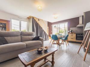 uma sala de estar com um sofá e uma mesa em Gîte calme près de Pornic avec wifi et animaux admis - FR-1-306-1311 em Chauvé