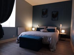 a bedroom with a large bed with blue walls at Maison plain-pied en Berry - Vue sur étang - Charges incluses - FR-1-591-748 in Migné