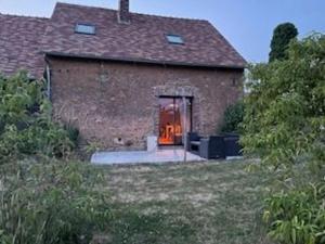 un grande edificio in mattoni con una porta con una finestra di Gîte de charme près du Mans pour 4 avec piscine naturelle - FR-1-410-473 a Teloché