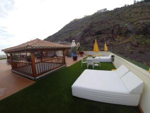 a room with a gazebo and a white couch at Apartamentos Tapahuga in Playa de Santiago