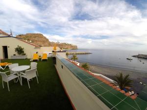 a balcony with a table and chairs and the ocean at Apartamentos Tapahuga in Playa de Santiago