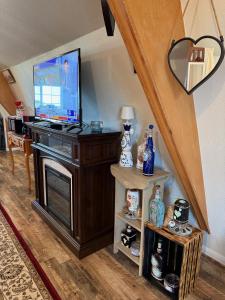 a living room with a flat screen tv on a stand at A Cozy Loft in Templeton in Templeton