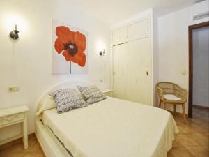 ein Schlafzimmer mit einem Bett mit einem roten Blumengemälde an der Wand in der Unterkunft Nice holiday home with private pool in Manacor + 19 Fotos