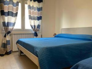 a bedroom with a blue bed and a window at Apartment in Rosolina Mare 49216 in Rosolina Mare +31 photos