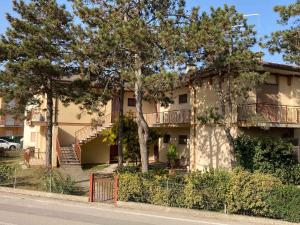 an apartment building with stairs and trees in front at Apartment in Rosolina Mare 49216 in Rosolina Mare