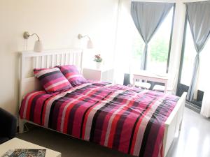 a bedroom with a bed with a striped comforter at Fenix Inn in Lund