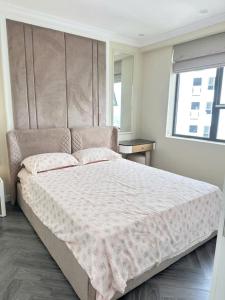 a bedroom with a large bed with a large headboard at SEE TRAVEL - Tecco Elite city Thai Nguyen 