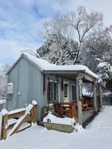 una piccola casa con la neve sopra di Jack Daniels Rest Gateway to Tekapo and the MacKenzie District a Burkes Pass