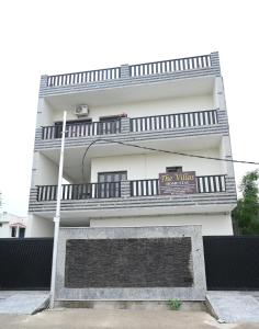 a tall white building with a sign on it at The Villas Homestay in Jammu