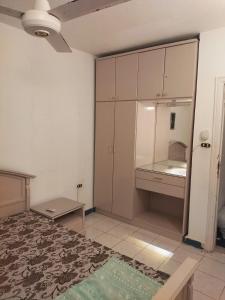 a room with a bed and a desk and cabinets at Riviera Dream Chalet in Dawwār al Ḩajj Aḩmad