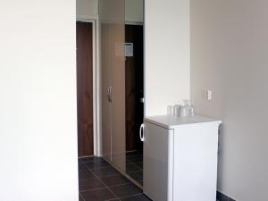 un piccolo frigorifero bianco in una stanza con porta di Fenix Inn a Lund