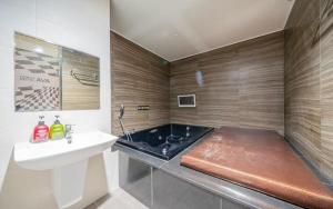 a bathroom with a sink and a bath tub at Changwon Ava Hotel in Changwon