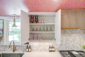 una cucina con un soffitto dipinto di rosa con bottiglie sugli scaffali di Maximalist IG-Worthy Bachelorette Vibes with Virtue, Saltwater Pool and Poolhouse a Grand Prairie