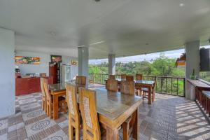 a dining room with tables and chairs and a balcony at WK Penida Cottage in Nusa Penida