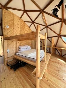 タンジュン・ルーにあるCoconest TWO Langkawiのユルトの木造の部屋にあるベッド