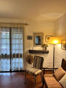 a living room with a couch and a lamp at Casita Amarillo Sol con Casa de Te, Pileta y Parrilla in Yerba Buena