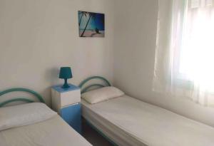 Dos camas individuales en una habitación con ventana. en Apartments in Rosolina Mare 25001, en Rosolina Mare