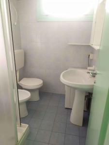 Un baño blanco con inodoro y lavabo. en Apartments in Rosolina Mare 25001, en Rosolina Mare