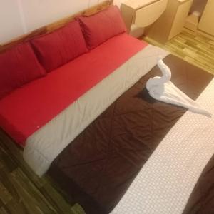 un letto rosso e bianco in una stanza di Good vibes a Kuilapayam