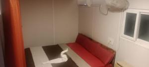 una stanza con un divano rosso con un cigno sul pavimento di Good vibes a Kuilapayam