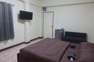 a bedroom with a bed and a flat screen tv at V Home Apartment in Ban Chek