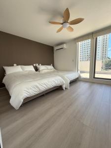 Un dormitorio con una cama grande con ventilador de techo. en 御宿ガーデンヴィラ, en Onjuku 76 fotos más